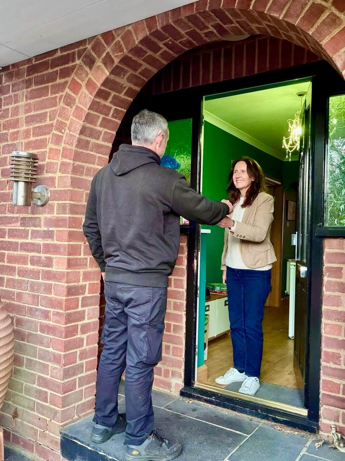 Returning keys to a customer after a mobile service Maxamy mobile mechanic handing keys back to a customer at her front door after completing a home car service.