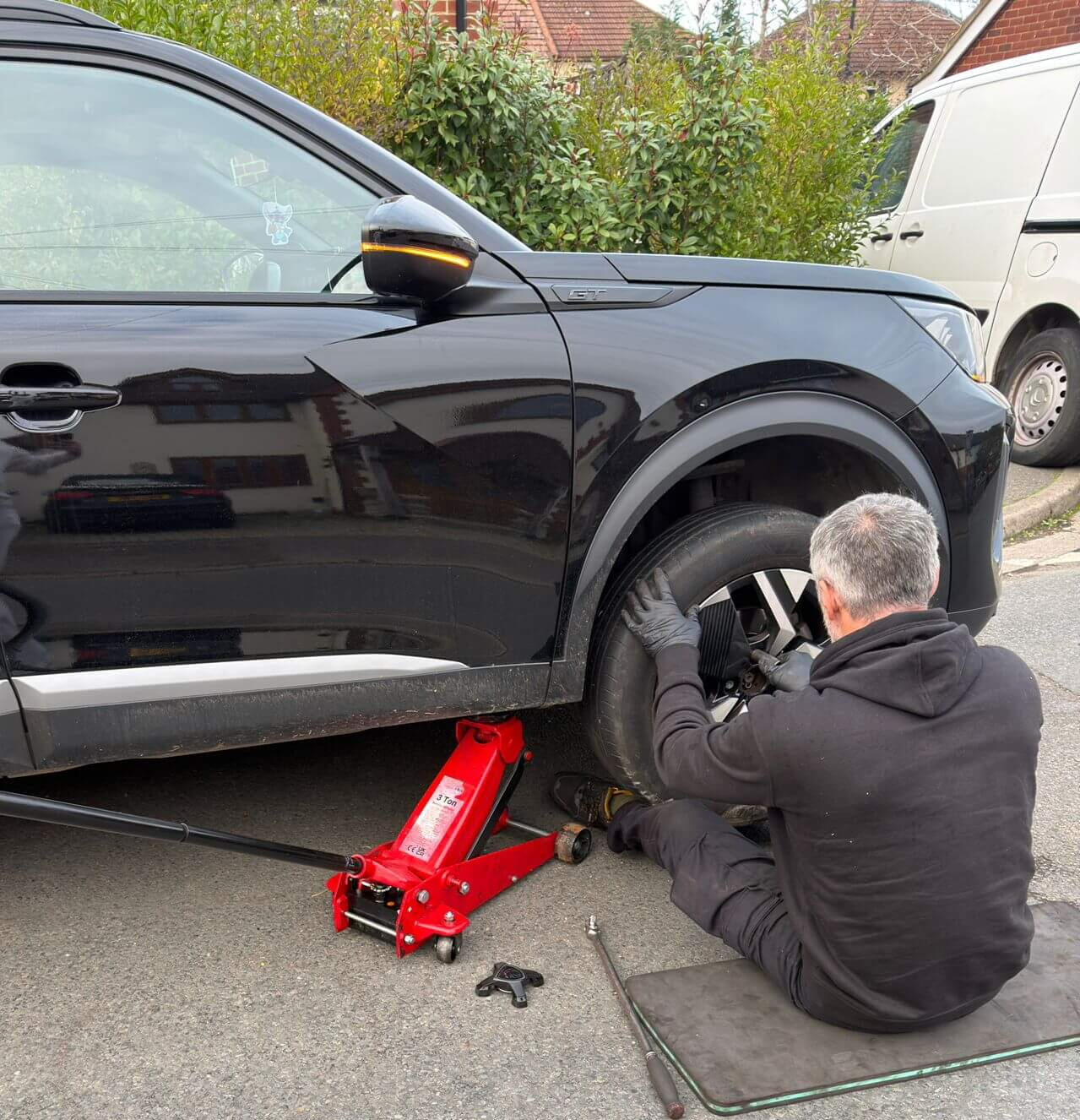 Mobile mechanic working roadside in Cookham Mobile mechanic repairing a vehicle at the roadside in Cookham, using a jack to remove the front wheel.